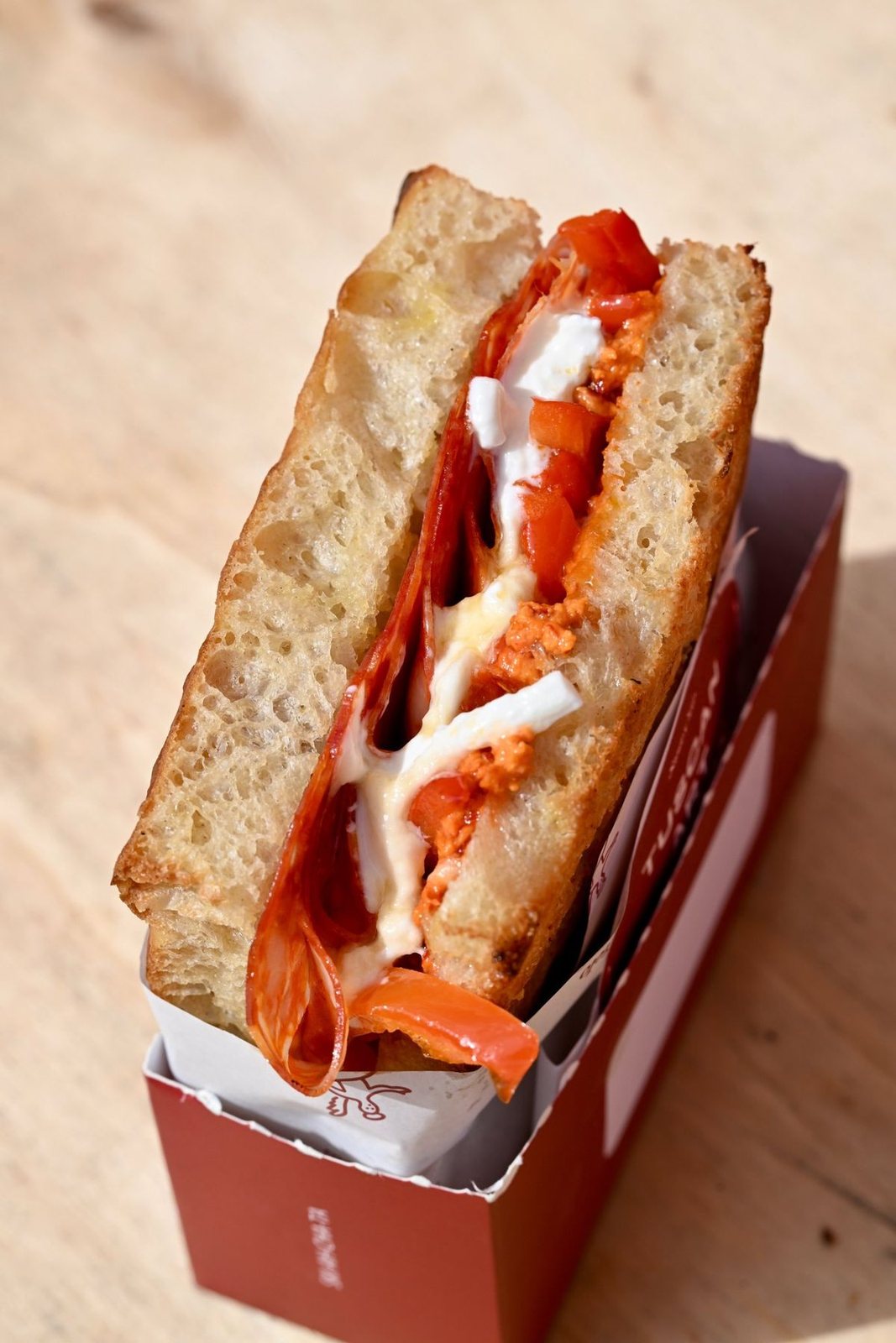 The Vesuvius up close in its red box: spicy salami, stracciatella and roasted peppers